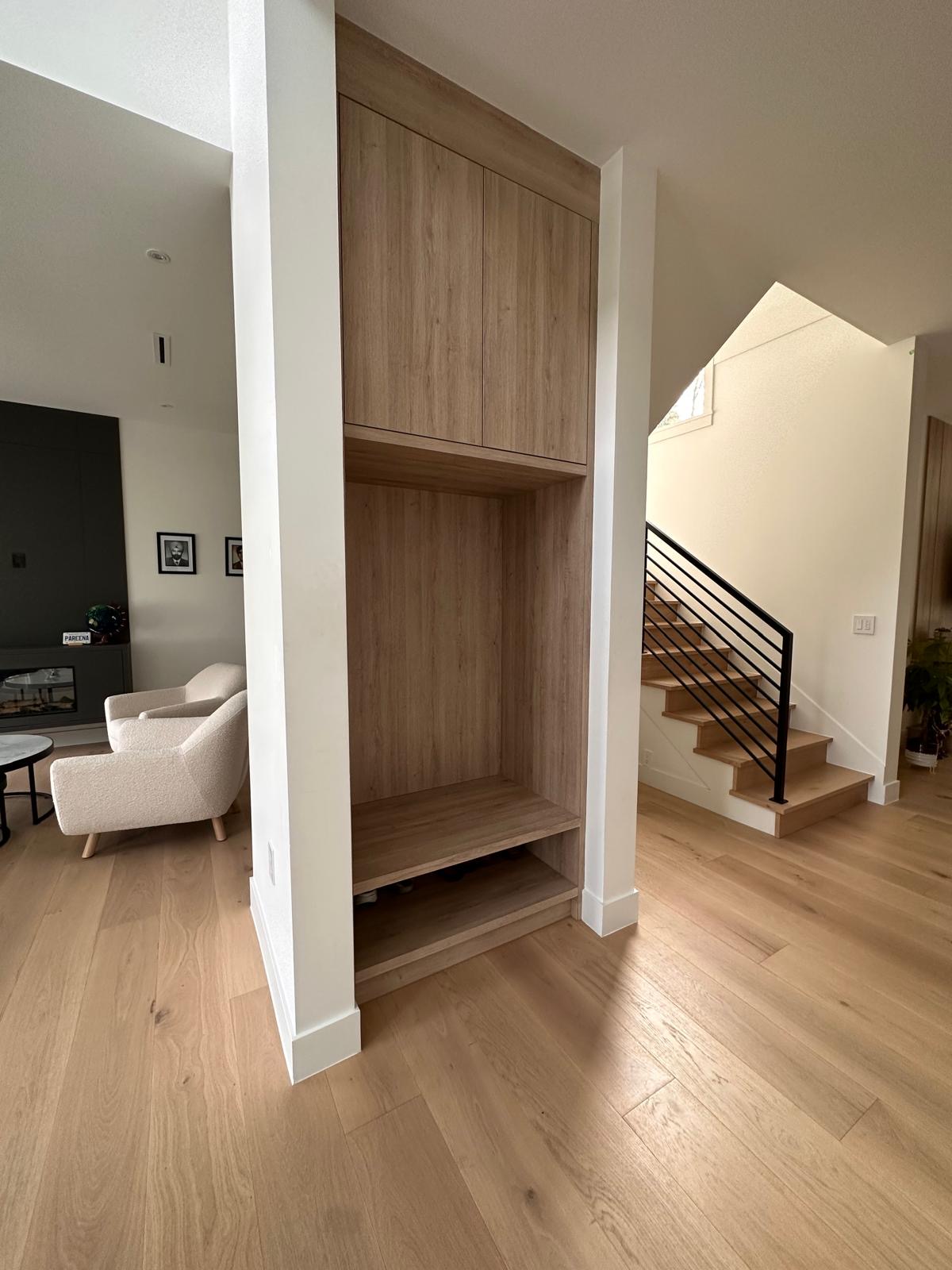 An entry with an oak bench and closet built in, the stair beyond.
