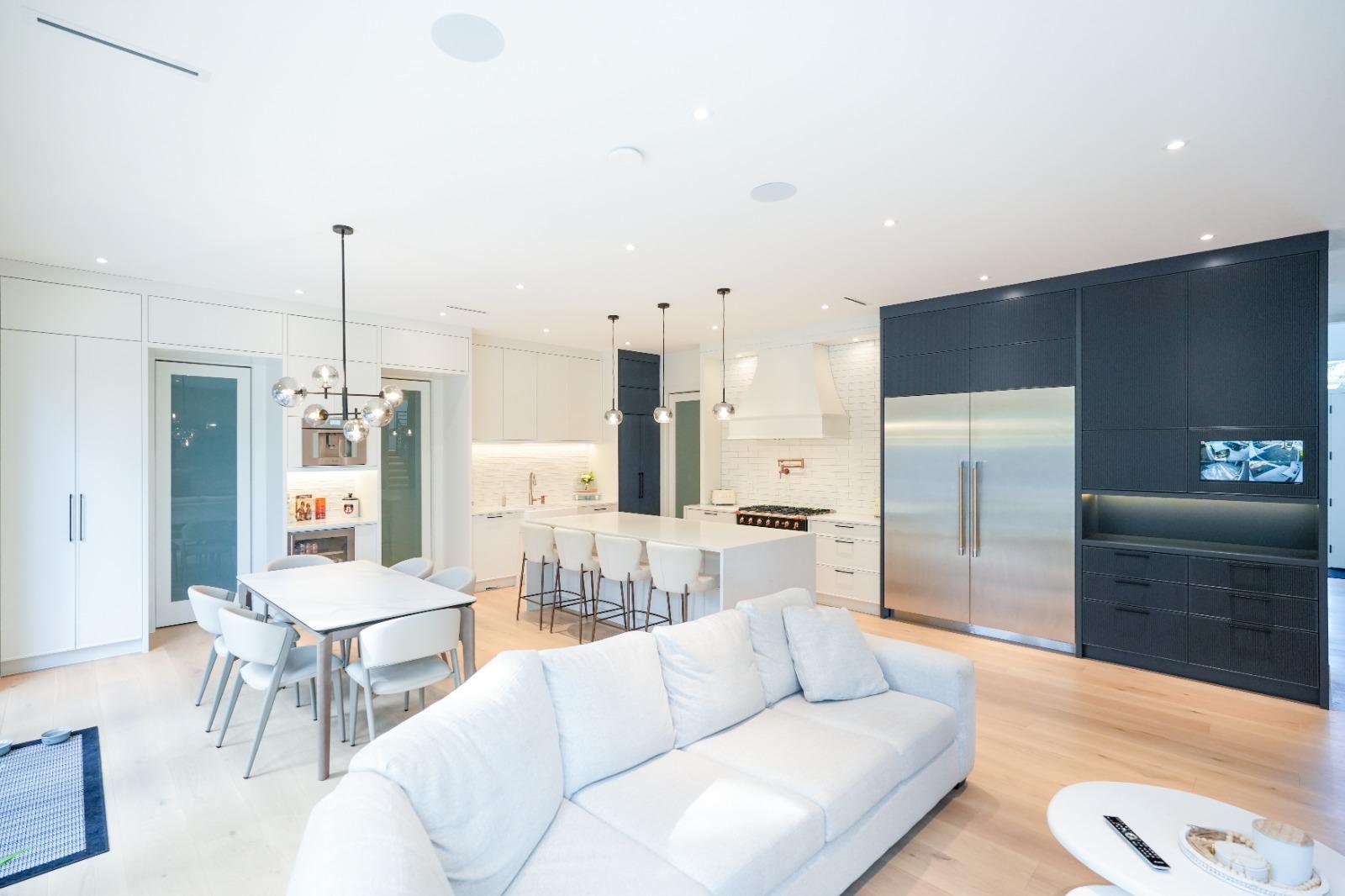 A finished great room: a white sofa, the dining table and the kitchen beyond.